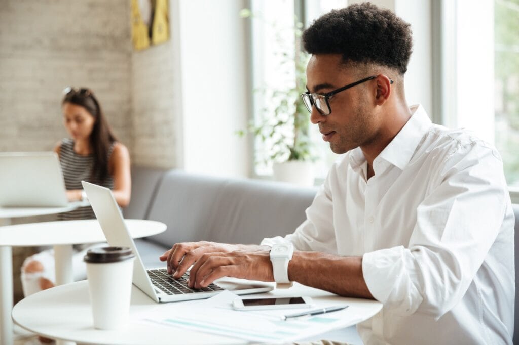 concentrated young african man sitting coworking